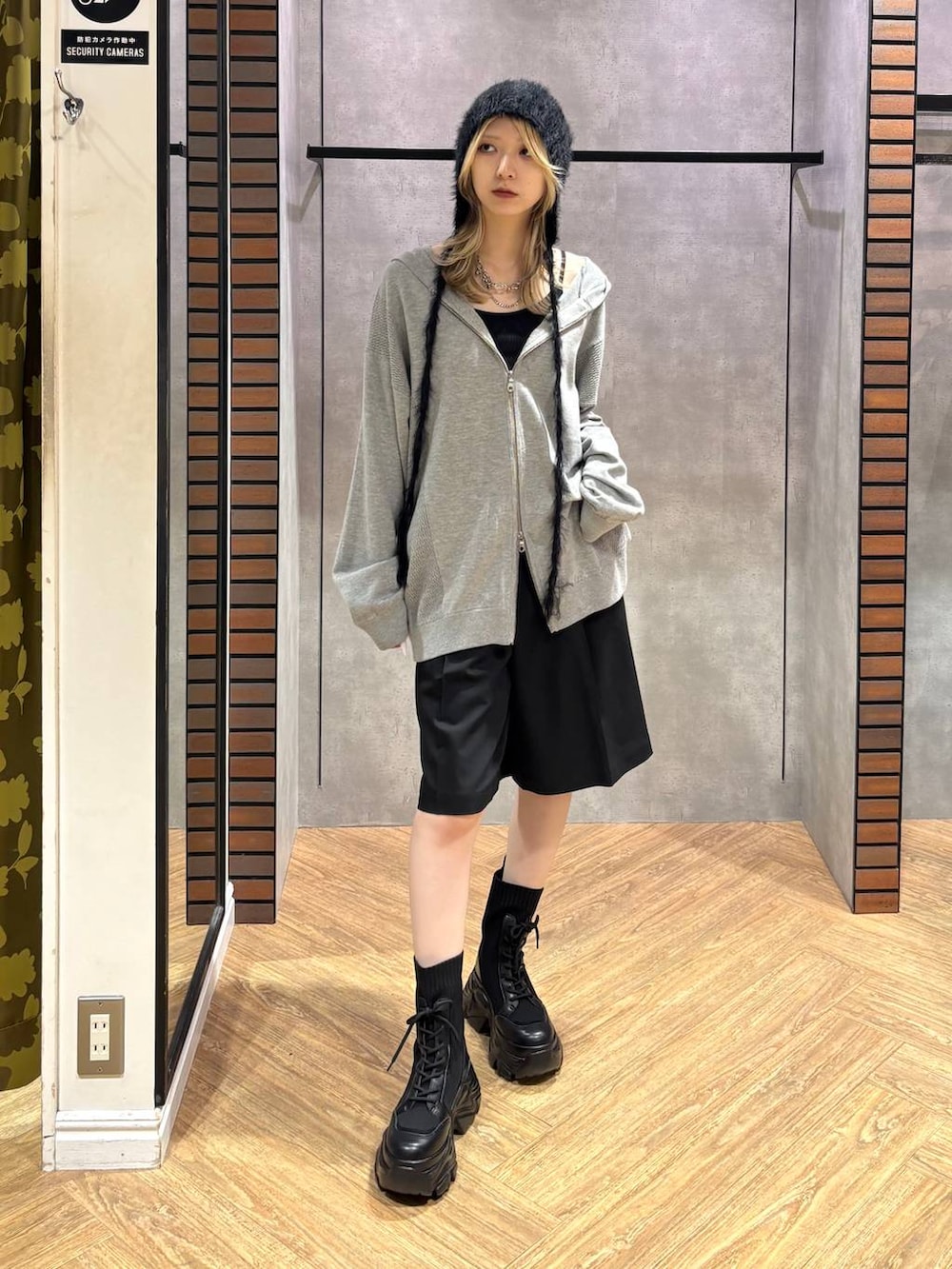 グレー系のパーカー、ブラック系のその他パンツ、ブラック系のブーツを着用したレディースの秋コーディネートの2枚目の写真