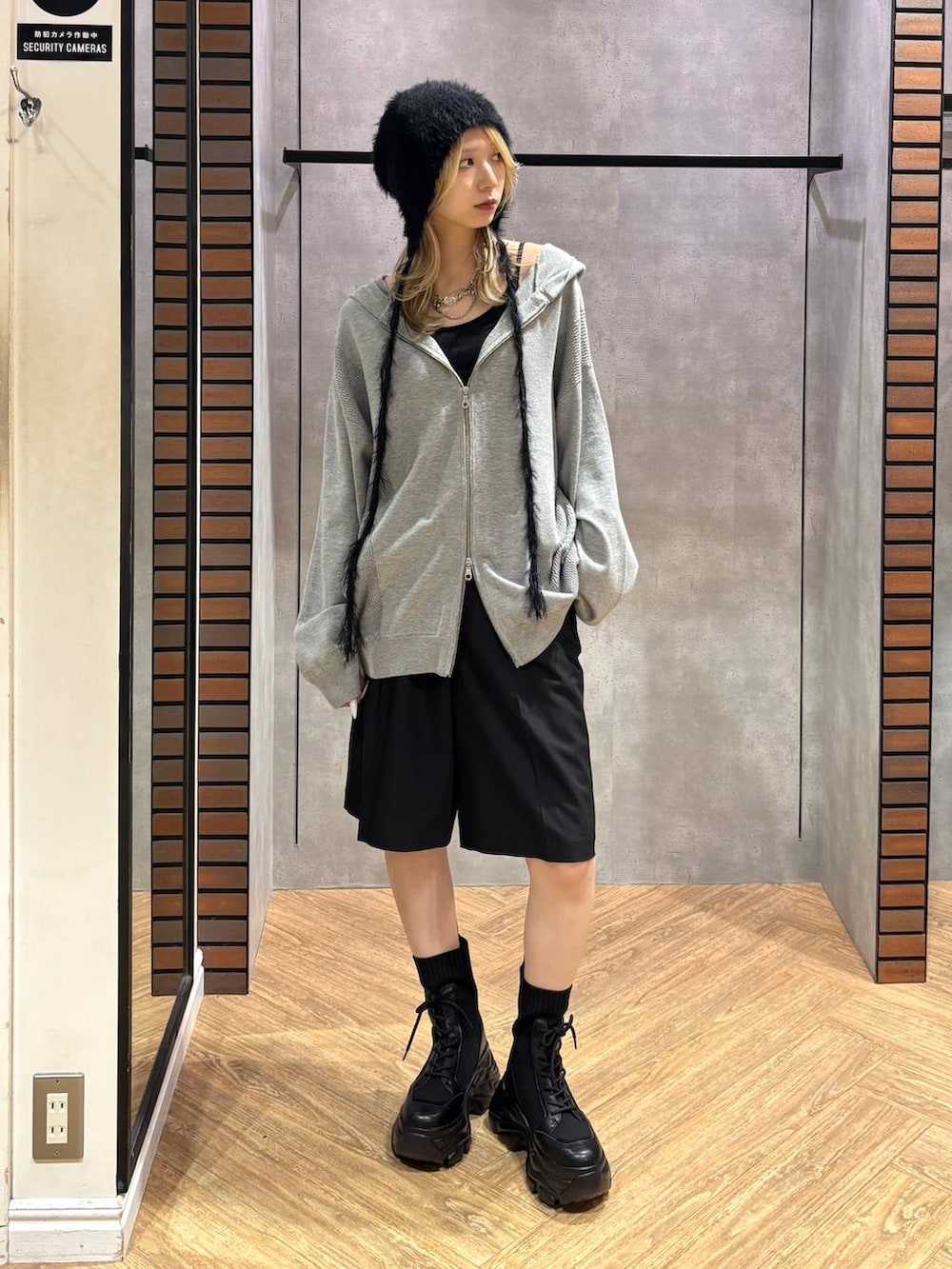 グレー系のパーカー、ブラック系のその他パンツ、ブラック系のブーツを着用したレディースの秋コーディネートの6枚目の写真
