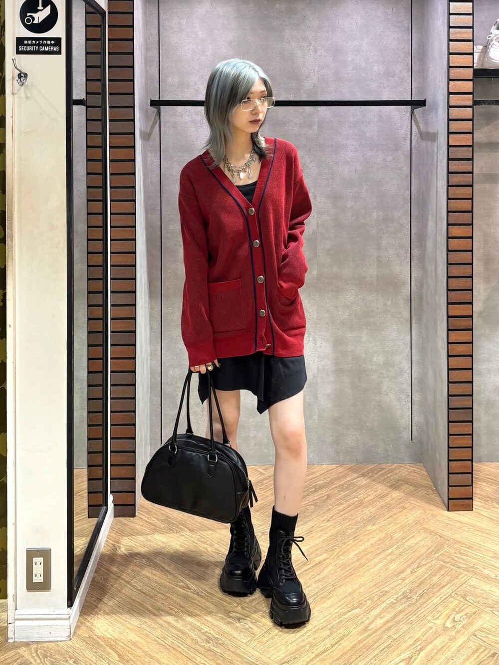 ブラック系のブーツ、ブラック系のキャミソール、ブラック系のスカートを着用したレディースの秋コーディネートの2枚目の写真