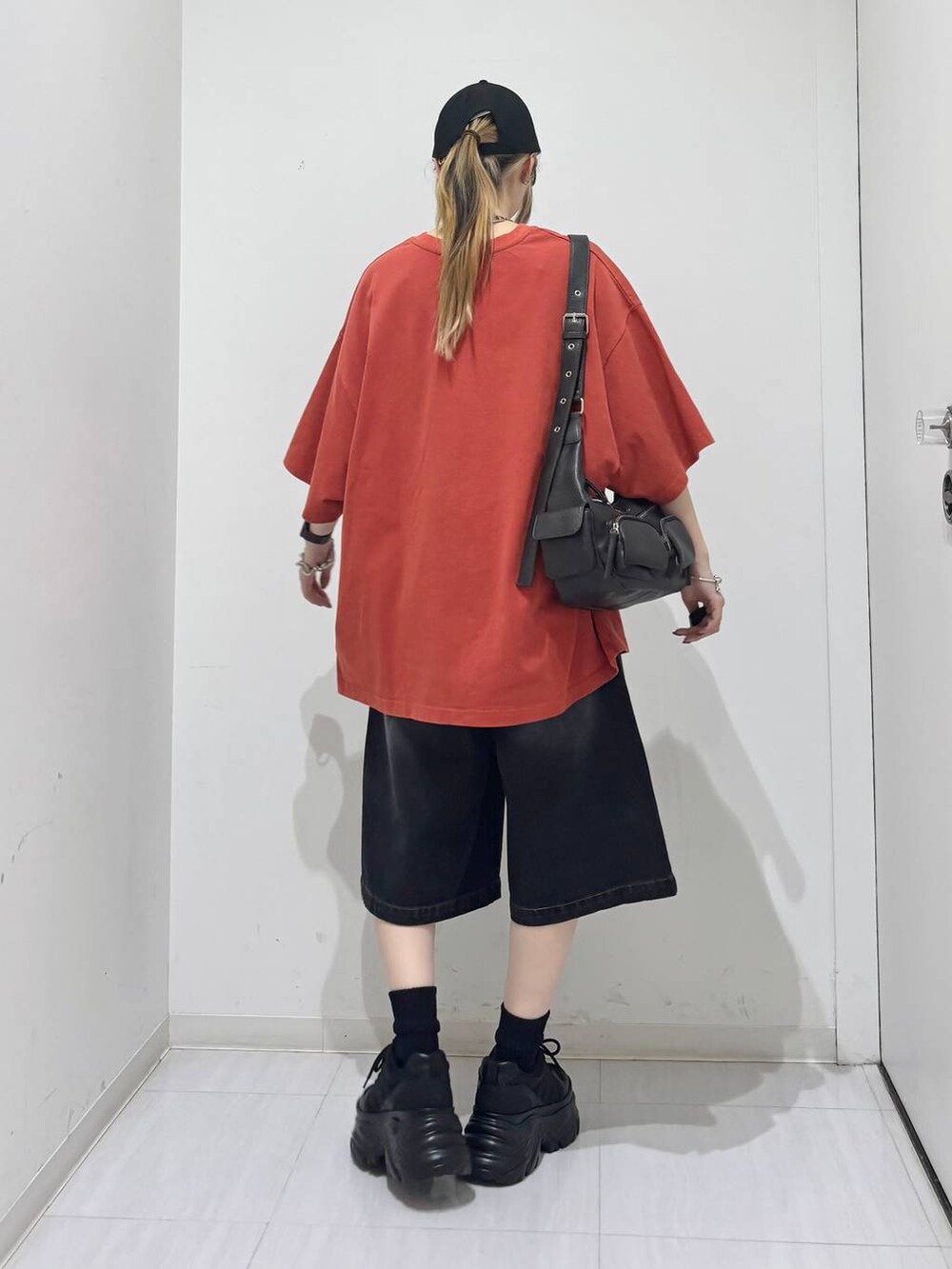 ブラック系のスニーカー、ブラック系のその他パンツ、レッド系のTシャツ/カットソーを着用したレディースの夏コーディネートの5枚目の写真