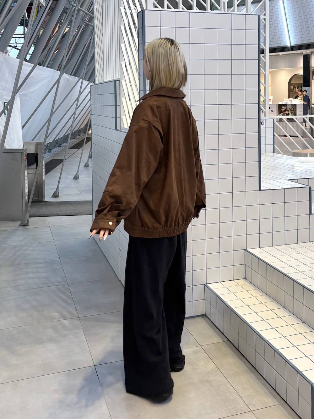 ブラック系のスニーカー、ブラック系のスウェットパンツ、ブラウン系のブルゾンを着用したレディースの冬コーディネートの5枚目の写真