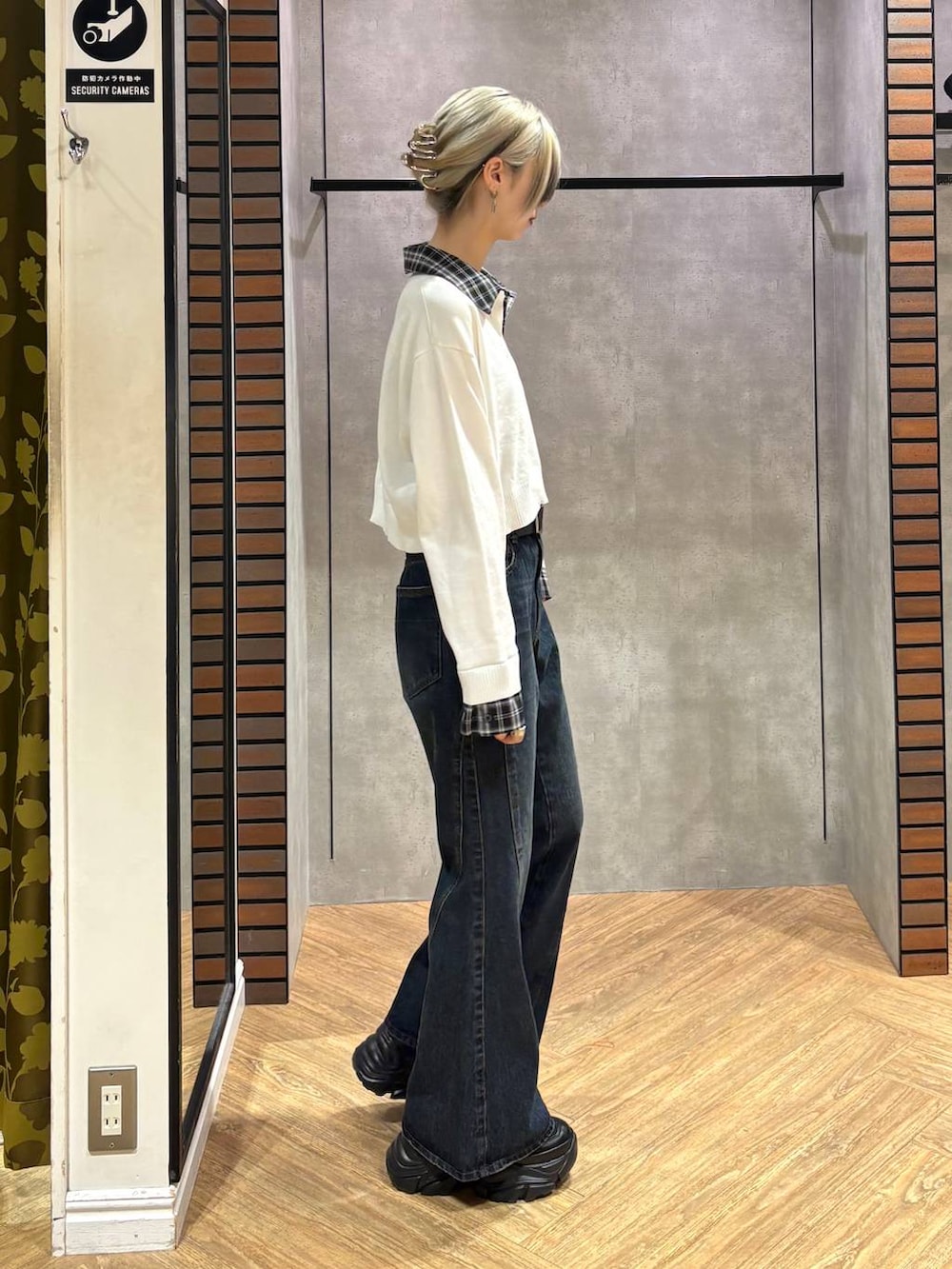 ブラック系のスニーカー、ブルー系のデニムパンツ、ホワイト系のニット/セーターを着用したレディースの秋コーディネートの6枚目の写真