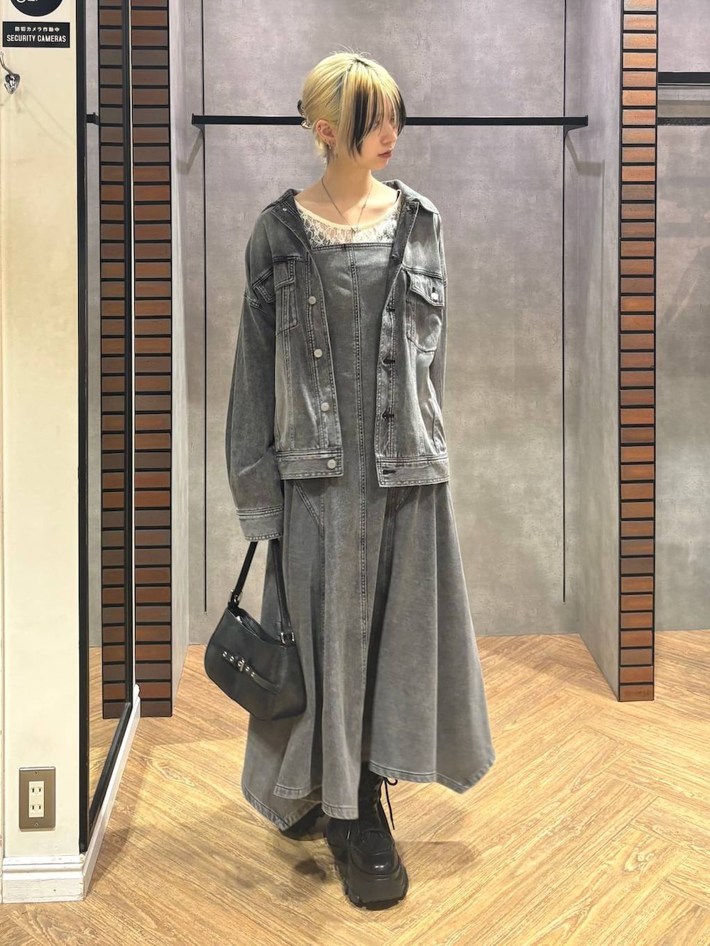 ブラック系のブーツ、ホワイト系のTシャツ/カットソー、ブラック系のハンドバッグを着用したレディースの冬コーディネートの3枚目の写真