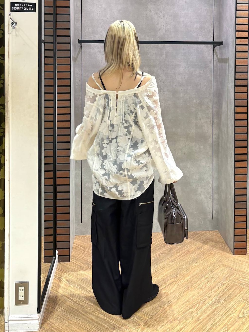 ブラック系のスニーカー、グレー系のショルダーバッグ、ホワイト系のTシャツ/カットソーを着用したレディースの冬コーディネートの5枚目の写真