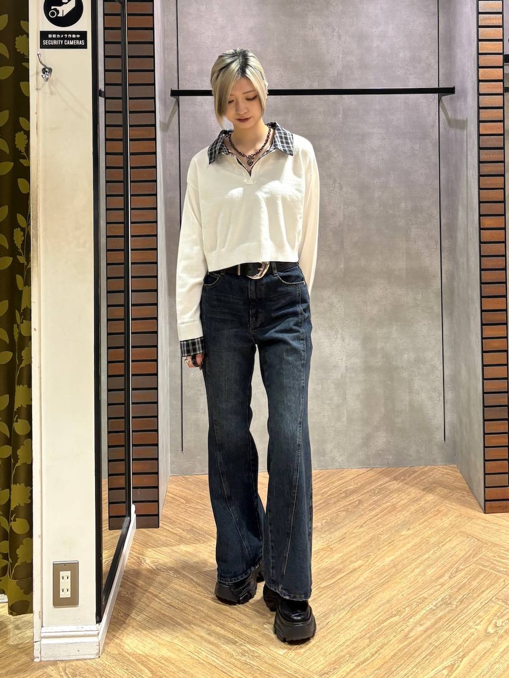 ブラック系のスニーカー、ブルー系のデニムパンツ、ホワイト系のニット/セーターを着用したレディースの秋コーディネートの7枚目の写真