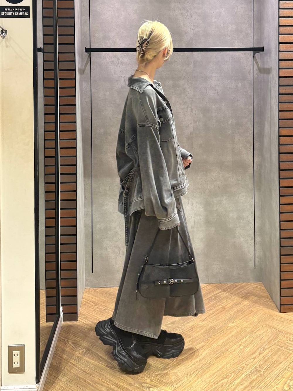 ブラック系のブーツ、ホワイト系のTシャツ/カットソー、ブラック系のハンドバッグを着用したレディースの冬コーディネートの7枚目の写真