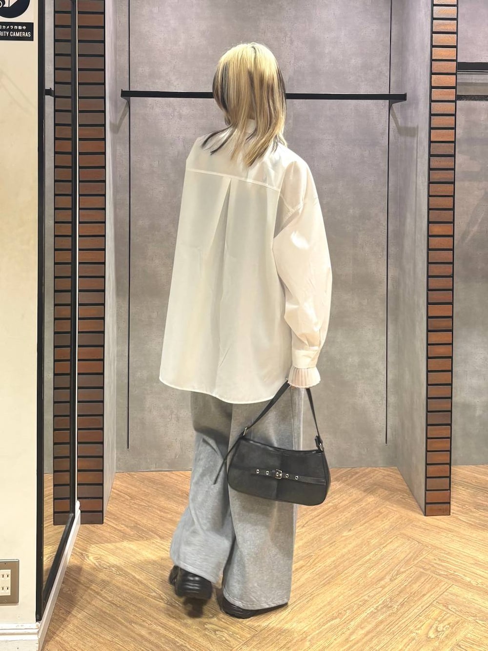 ブラック系のスニーカー、グレー系のスウェットパンツ、ブラック系のハンドバッグを着用したレディースの冬コーディネートの4枚目の写真