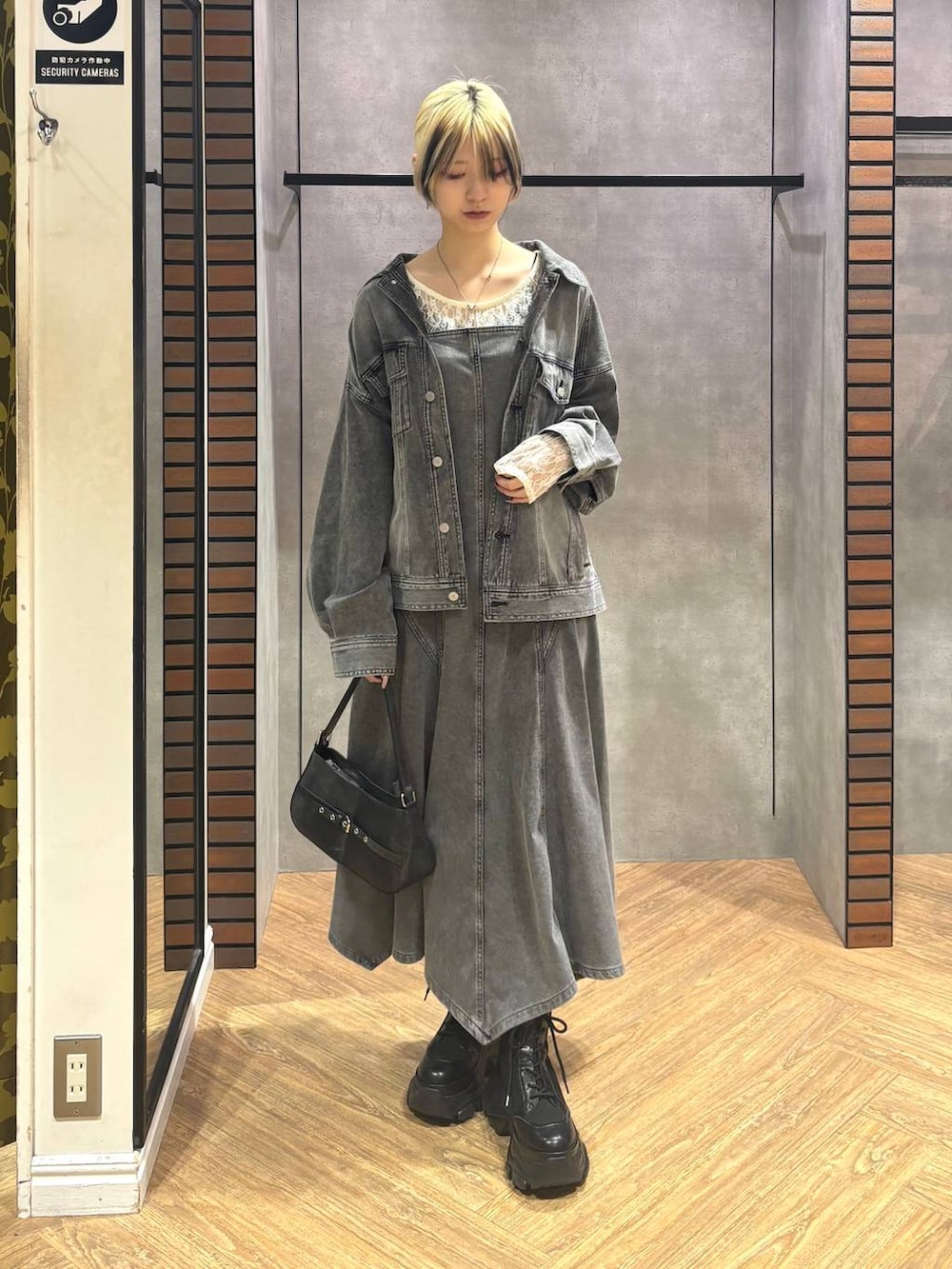 ブラック系のブーツ、ホワイト系のTシャツ/カットソー、ブラック系のハンドバッグを着用したレディースの冬コーディネートの8枚目の写真