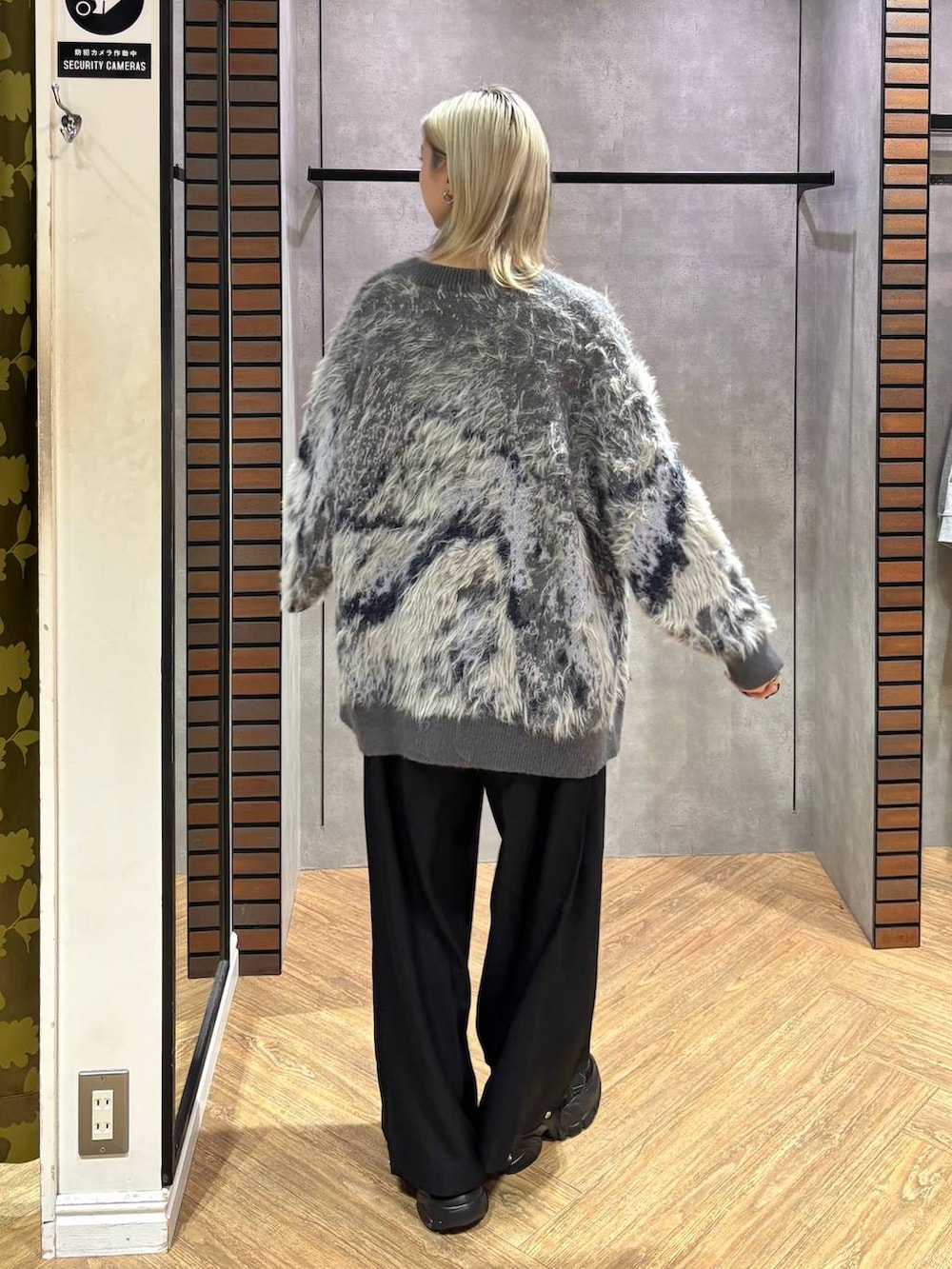 ブラック系のスニーカー、グレー系のカーディガン/ボレロ、ブラック系のスラックスを着用したレディースの秋コーディネートの4枚目の写真