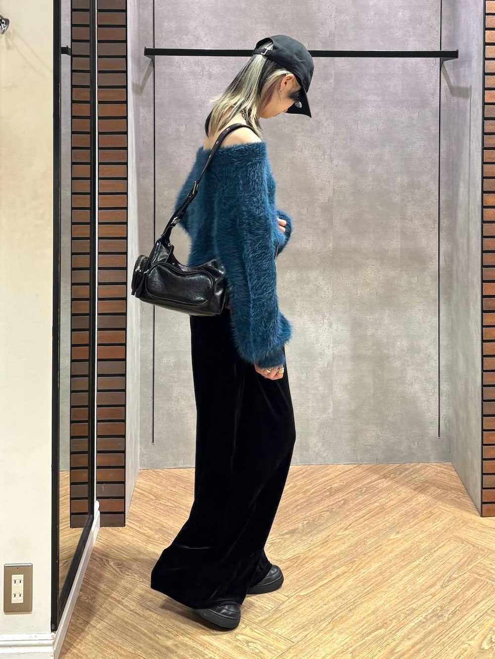 ブラック系のショルダーバッグ、ブルー系のニット/セーター、ブラック系のその他パンツを着用したレディースの冬コーディネートの6枚目の写真