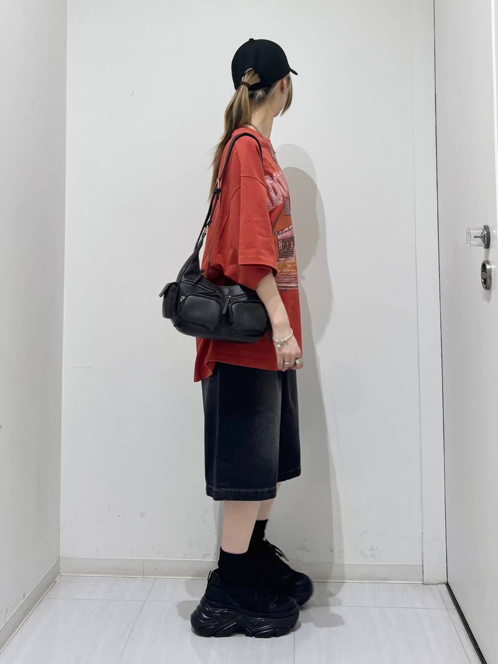 ブラック系のスニーカー、ブラック系のその他パンツ、レッド系のTシャツ/カットソーを着用したレディースの夏コーディネートの6枚目の写真