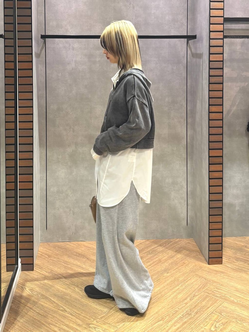 ブラウン系のボストンバッグ、ブラック系のスニーカー、グレー系のスウェットパンツを着用したレディースの冬コーディネートの5枚目の写真