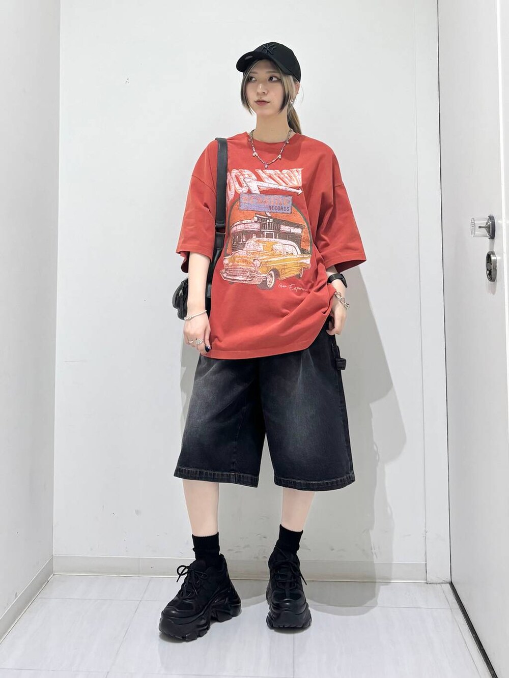 ブラック系のスニーカー、ブラック系のその他パンツ、レッド系のTシャツ/カットソーを着用したレディースの夏コーディネートの3枚目の写真
