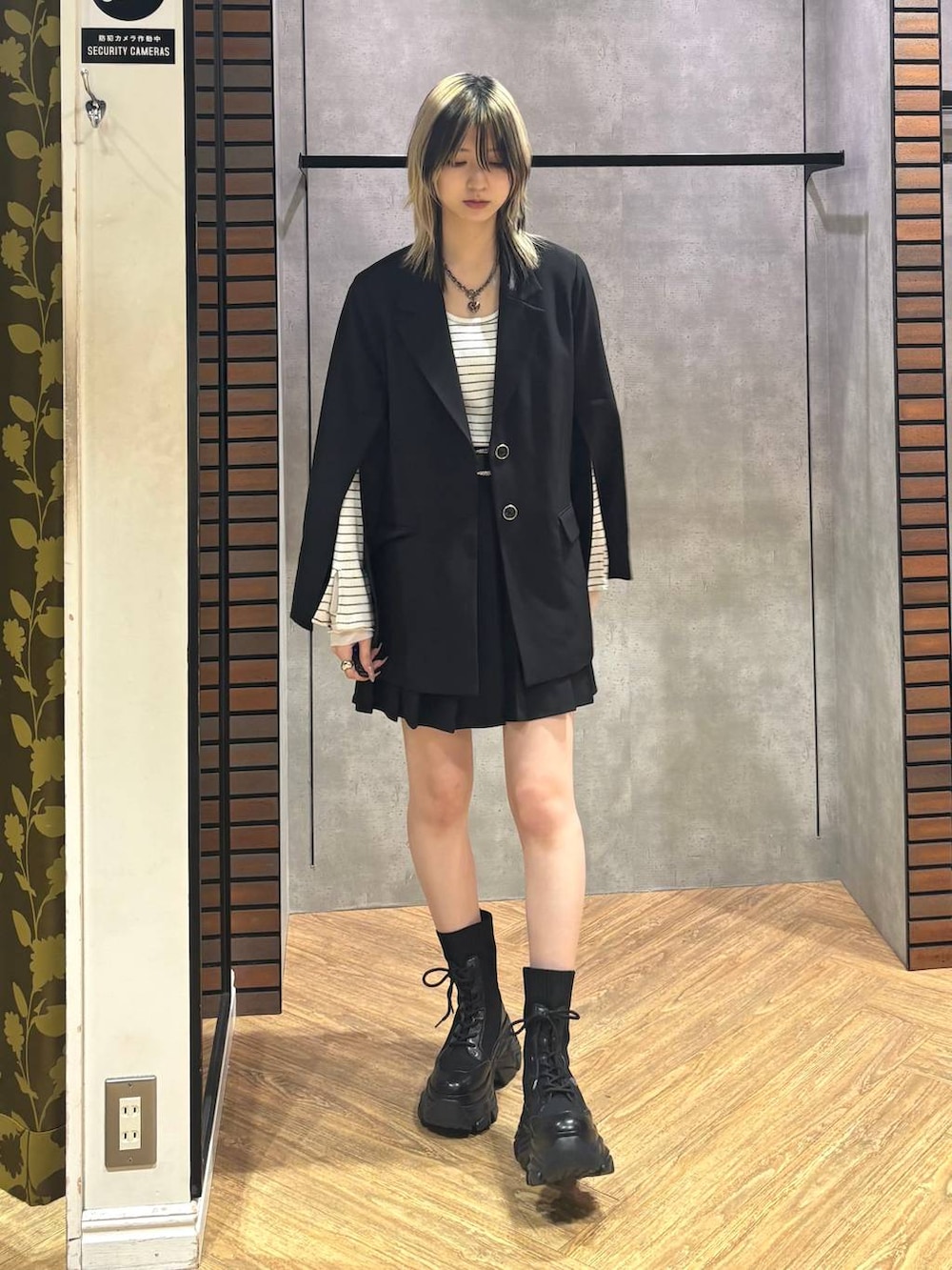 ブラック系のブーツ、ブラック系のテーラードジャケット、ホワイト系のTシャツ/カットソーを着用したレディースの冬コーディネートの2枚目の写真