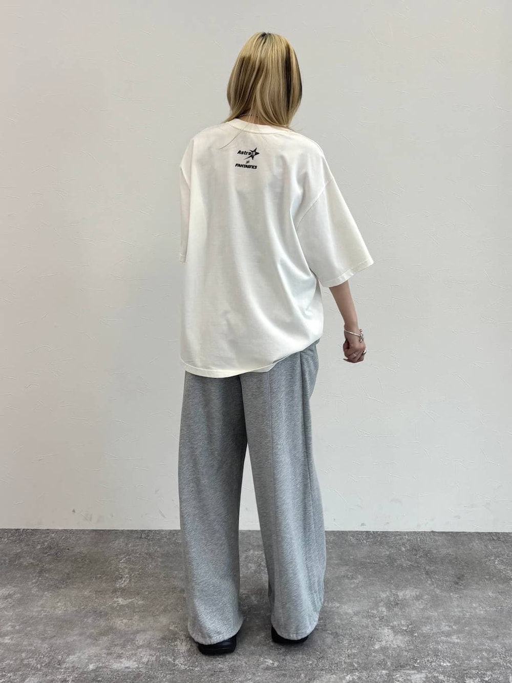 ブラック系のスニーカー、グレー系のスウェットパンツ、ホワイト系のTシャツ/カットソーを着用したレディースの春コーディネートの6枚目の写真