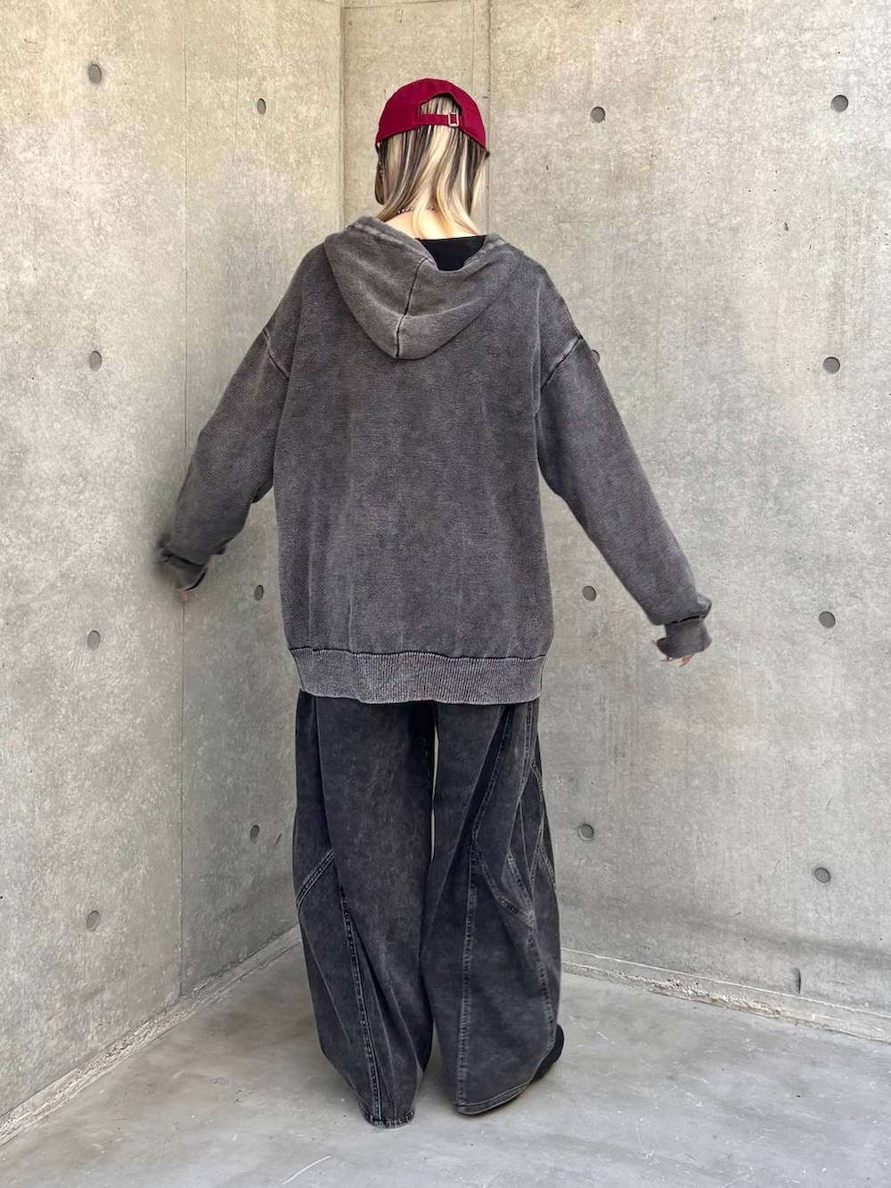 ブラック系のスニーカー、グレー系のパーカー、ブラック系のデニムパンツを着用したレディースの冬コーディネートの4枚目の写真