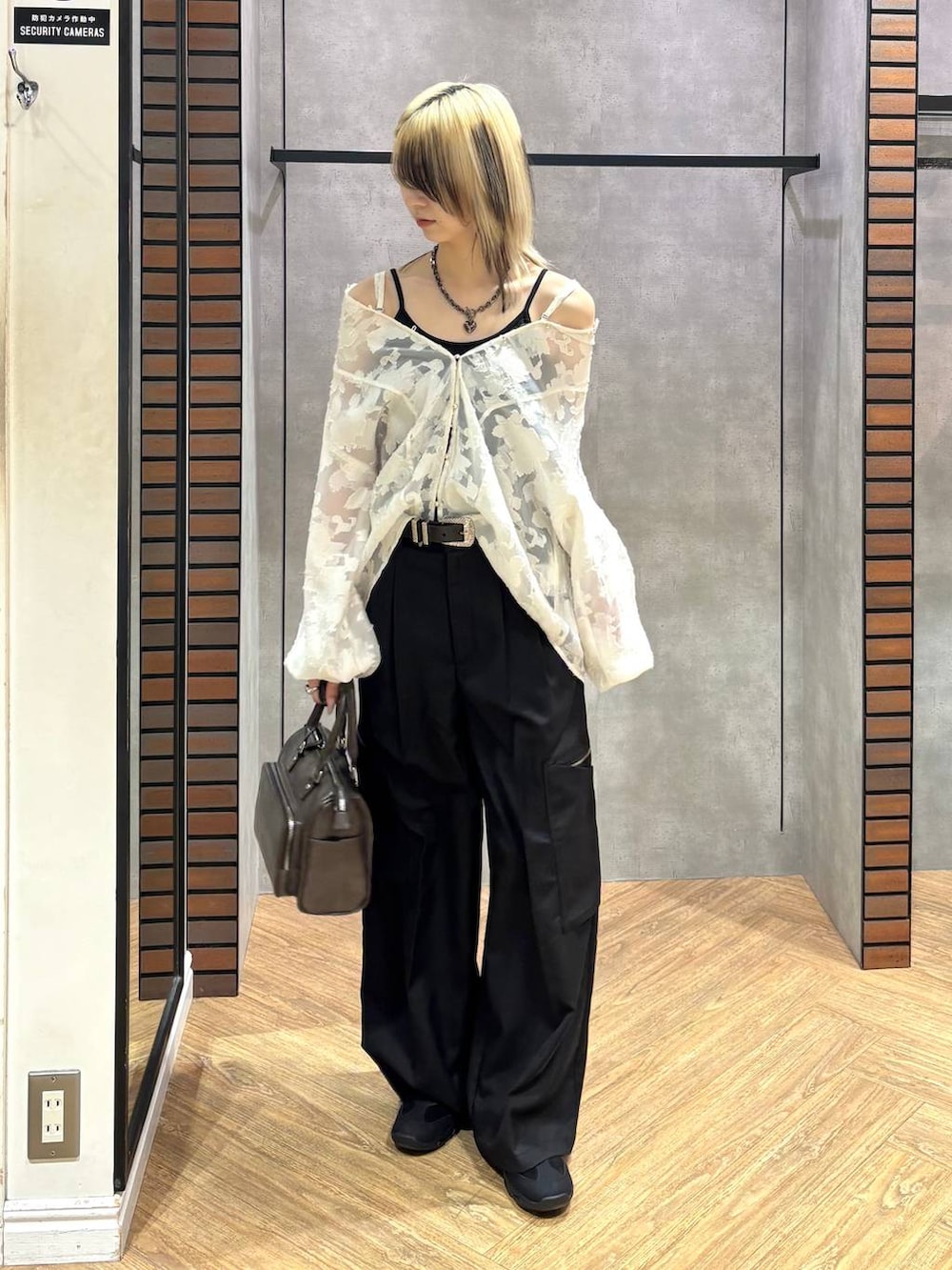 ブラック系のスニーカー、グレー系のショルダーバッグ、ホワイト系のTシャツ/カットソーを着用したレディースの冬コーディネートの2枚目の写真