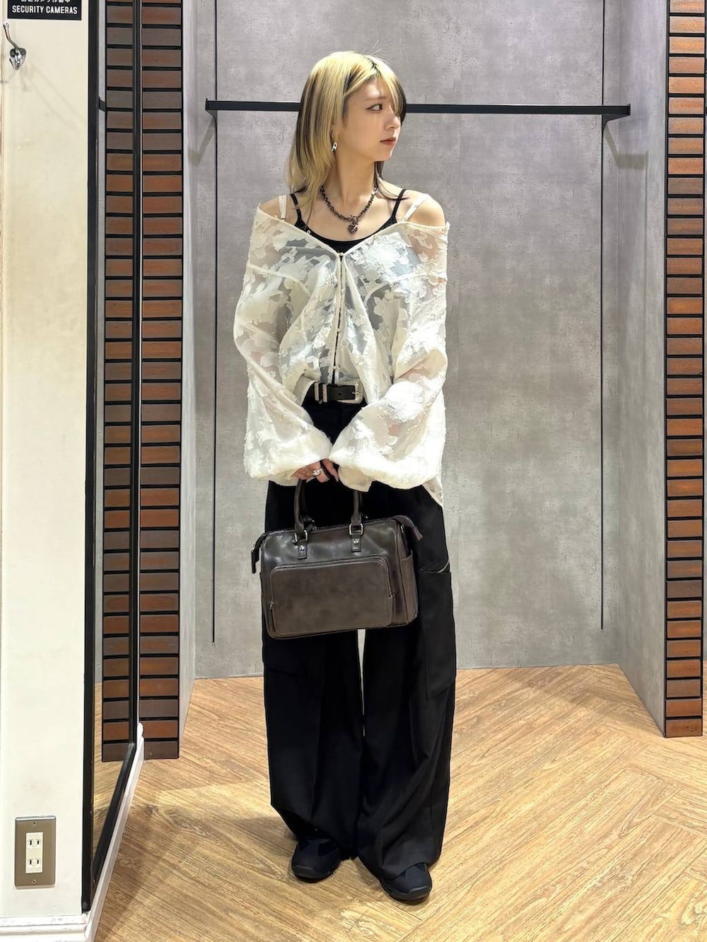 ブラック系のスニーカー、グレー系のショルダーバッグ、ホワイト系のTシャツ/カットソーを着用したレディースの冬コーディネートの3枚目の写真