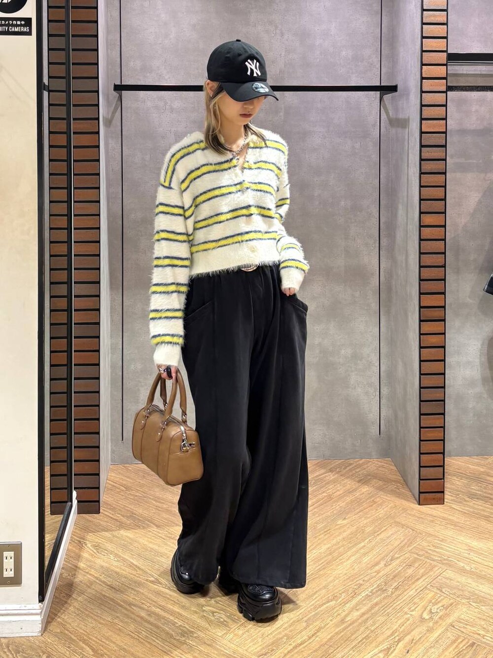 ブラック系のスニーカー、ブラウン系のボストンバッグ、ホワイト系のニット/セーターを着用したレディースの冬コーディネートの7枚目の写真