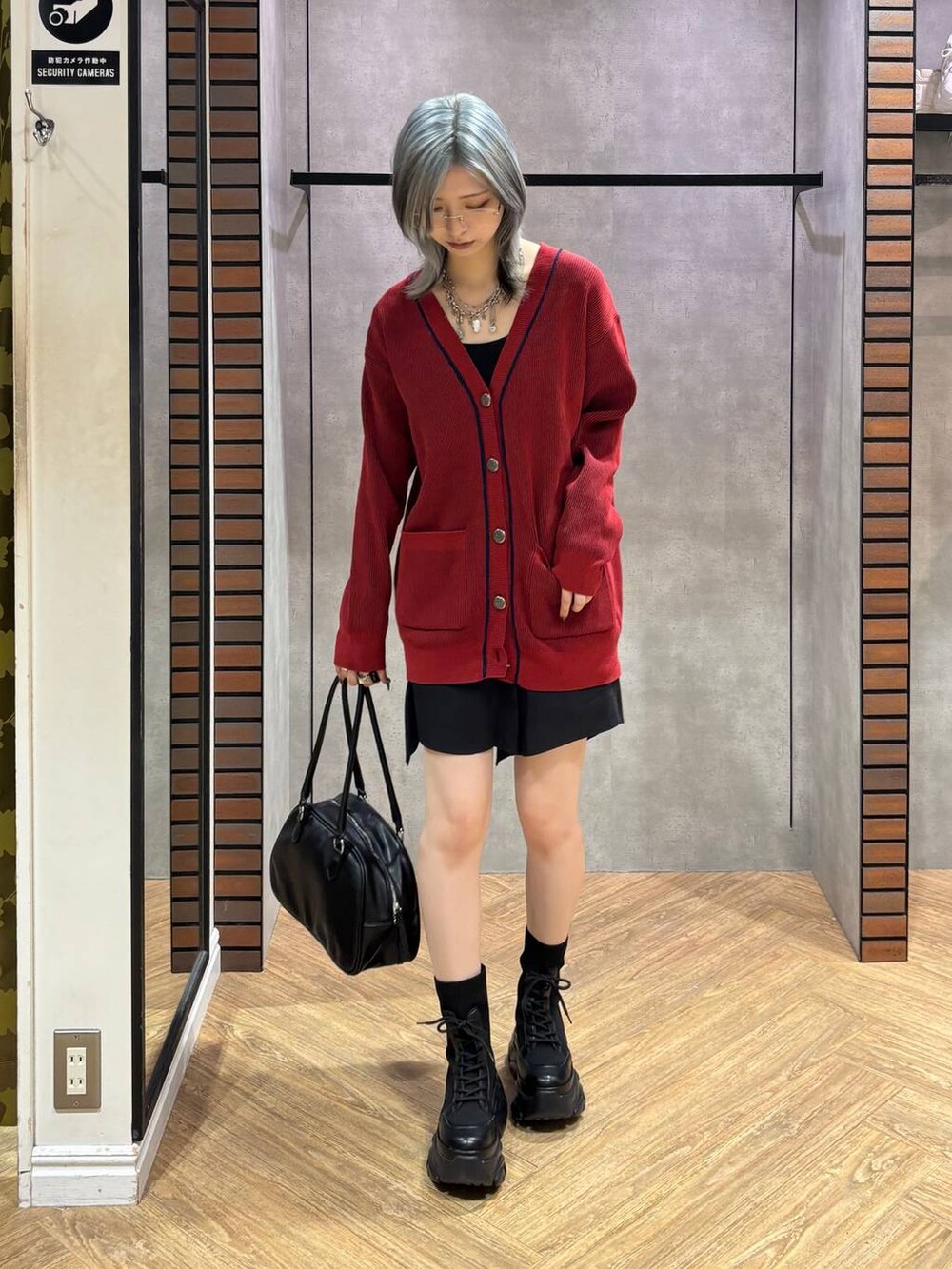 ブラック系のブーツ、ブラック系のキャミソール、ブラック系のスカートを着用したレディースの秋コーディネートの7枚目の写真