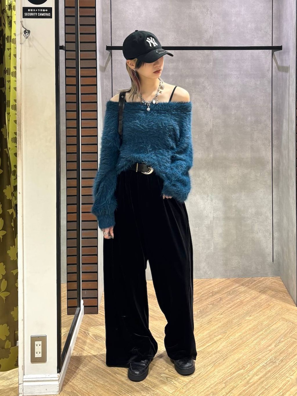 ブラック系のショルダーバッグ、ブルー系のニット/セーター、ブラック系のその他パンツを着用したレディースの冬コーディネートの2枚目の写真