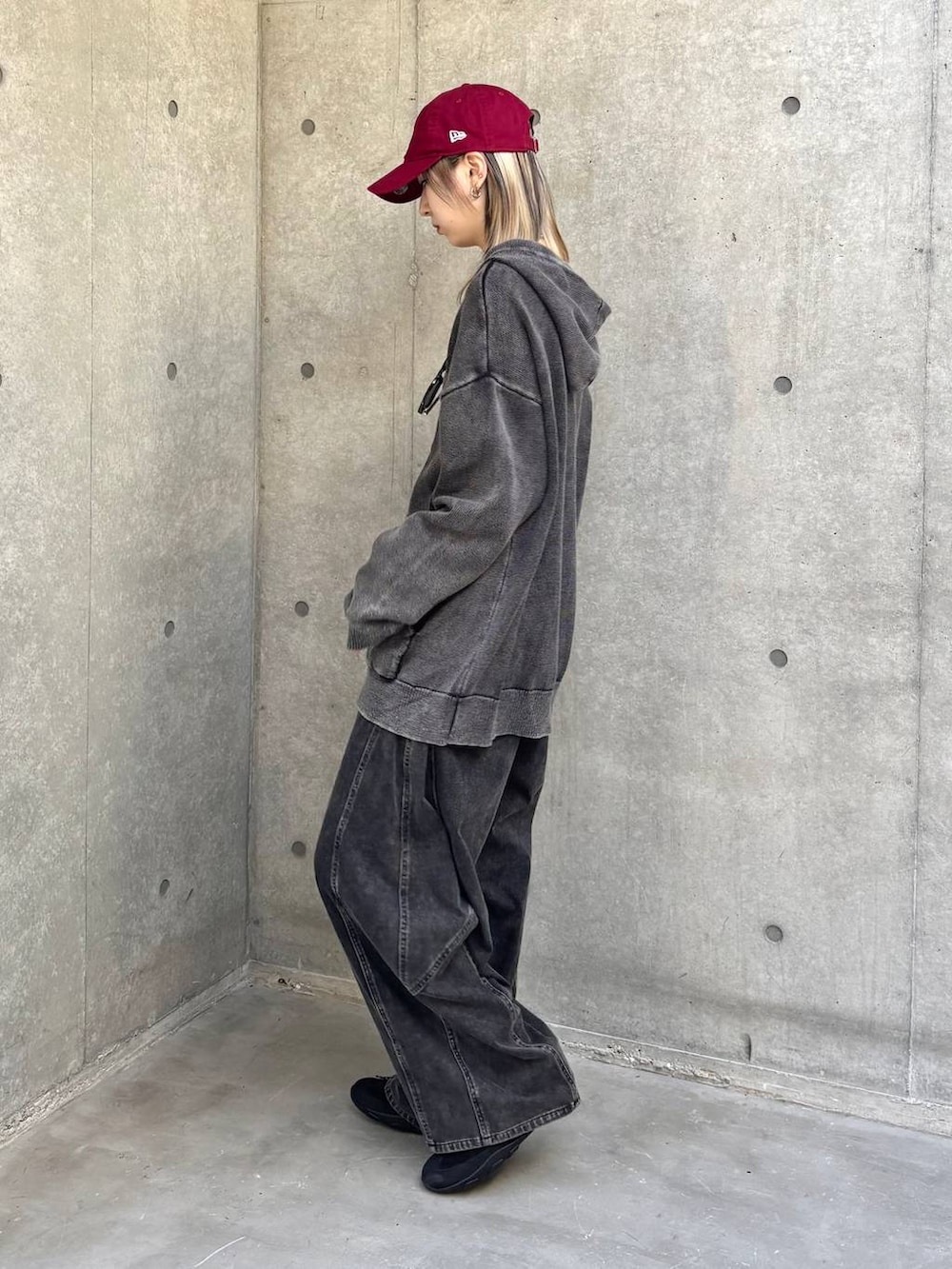 ブラック系のスニーカー、グレー系のパーカー、ブラック系のデニムパンツを着用したレディースの冬コーディネートの3枚目の写真