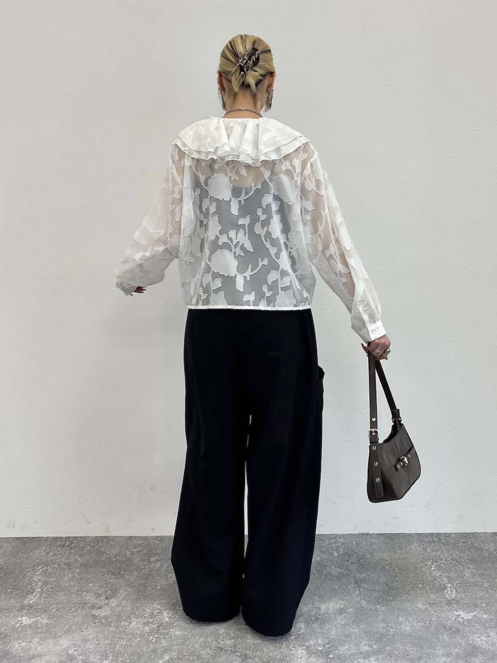 ブラウン系のハンドバッグ、ブラック系のサンダル、ホワイト系のシャツ/ブラウスを着用したレディースの春コーディネートの3枚目の写真