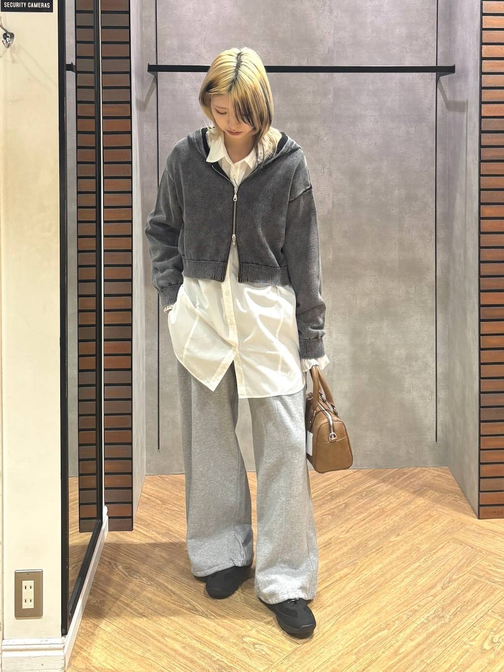 ブラウン系のボストンバッグ、ブラック系のスニーカー、グレー系のスウェットパンツを着用したレディースの冬コーディネートの3枚目の写真