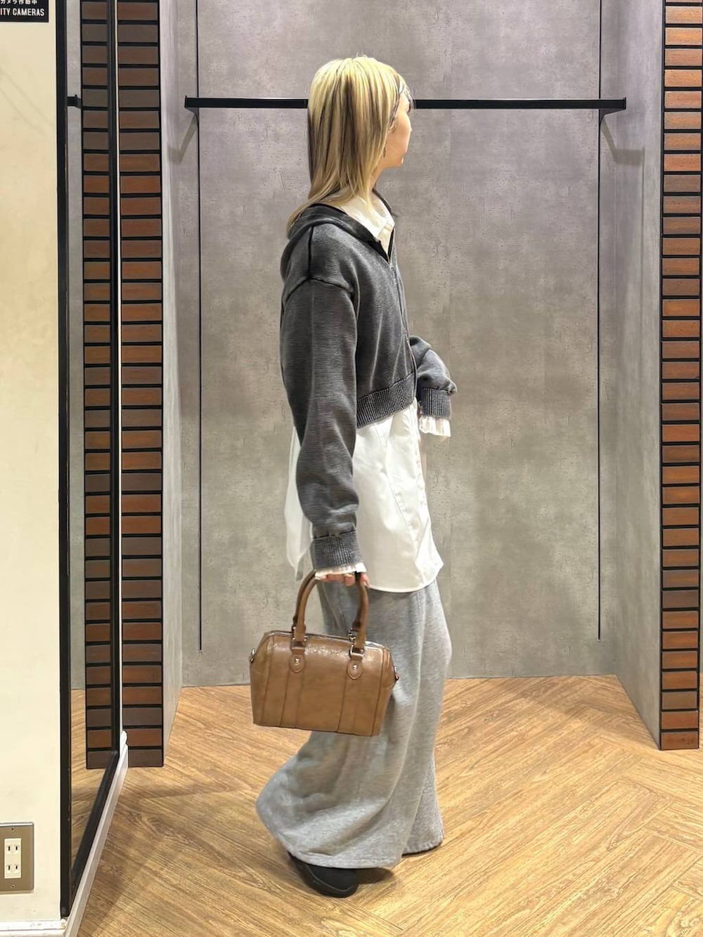 ブラウン系のボストンバッグ、ブラック系のスニーカー、グレー系のスウェットパンツを着用したレディースの冬コーディネートの7枚目の写真