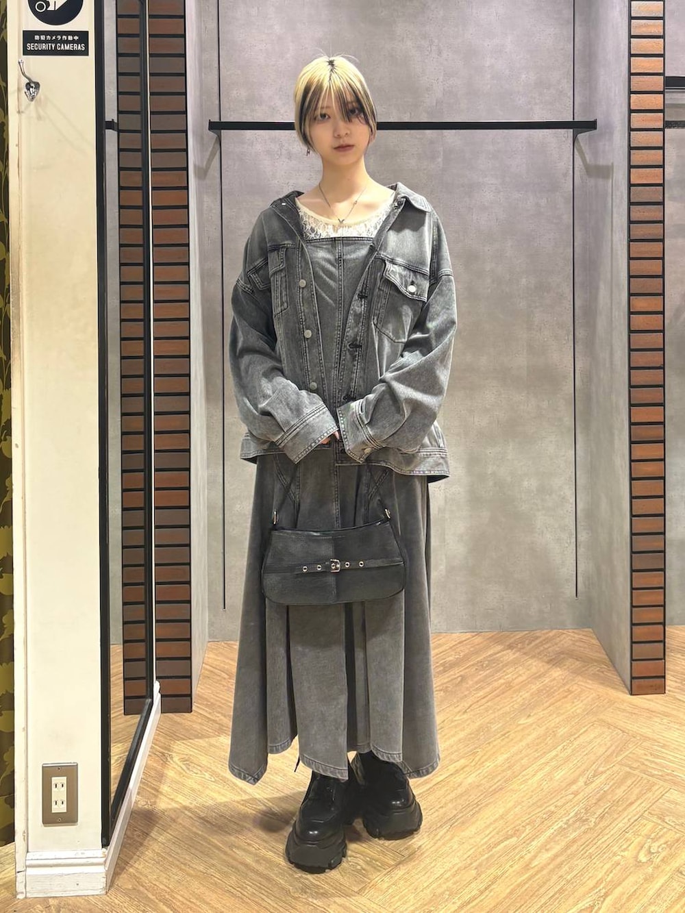 ブラック系のブーツ、ホワイト系のTシャツ/カットソー、ブラック系のハンドバッグを着用したレディースの冬コーディネートの2枚目の写真