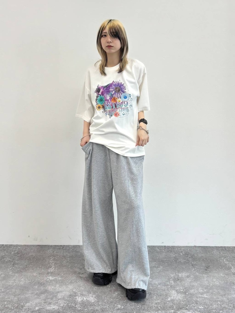 ブラック系のスニーカー、グレー系のスウェットパンツ、ホワイト系のTシャツ/カットソーを着用したレディースの春コーディネートの8枚目の写真