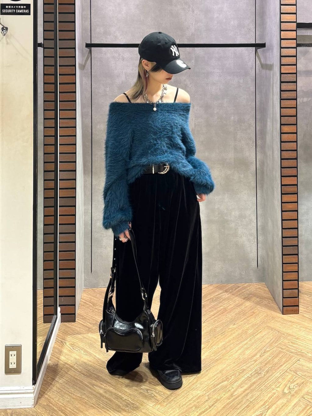 ブラック系のショルダーバッグ、ブルー系のニット/セーター、ブラック系のその他パンツを着用したレディースの冬コーディネートの3枚目の写真