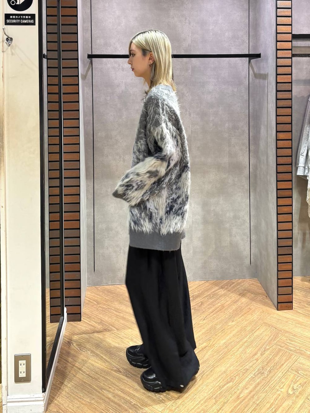 ブラック系のスニーカー、グレー系のカーディガン/ボレロ、ブラック系のスラックスを着用したレディースの秋コーディネートの3枚目の写真