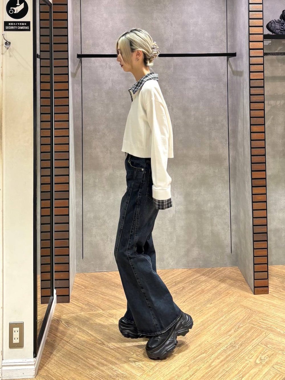 ブラック系のスニーカー、ブルー系のデニムパンツ、ホワイト系のニット/セーターを着用したレディースの秋コーディネートの4枚目の写真