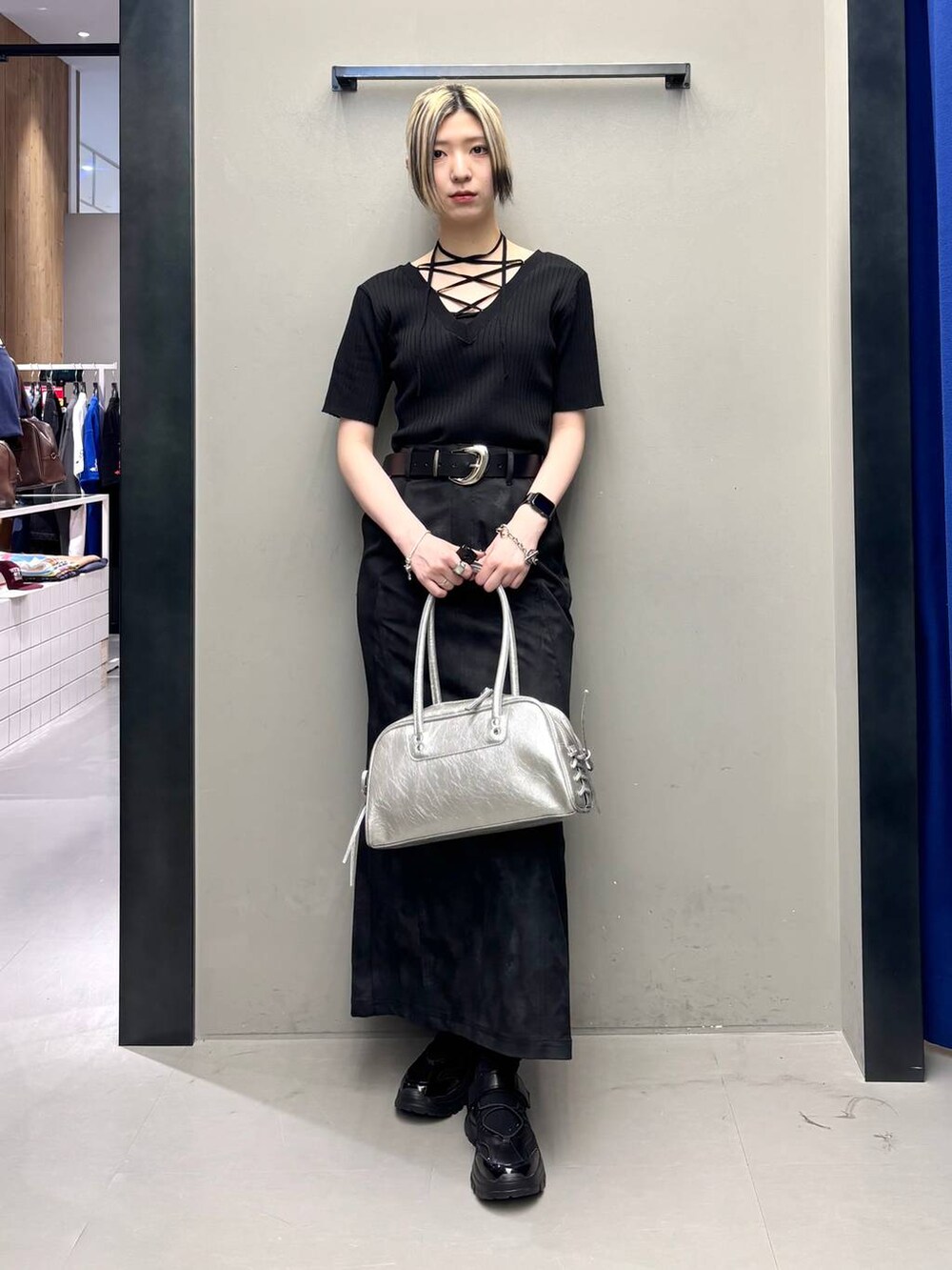 ブラック系のスニーカー、シルバー系のショルダーバッグ、ブラック系のニット/セーターを着用したレディースの春コーディネートの3枚目の写真