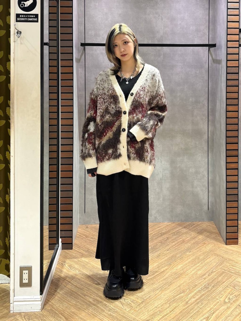 ブラック系のブーツ、ブラック系のニット/セーター、ホワイト系のカーディガン/ボレロを着用したレディースの冬コーディネートの7枚目の写真