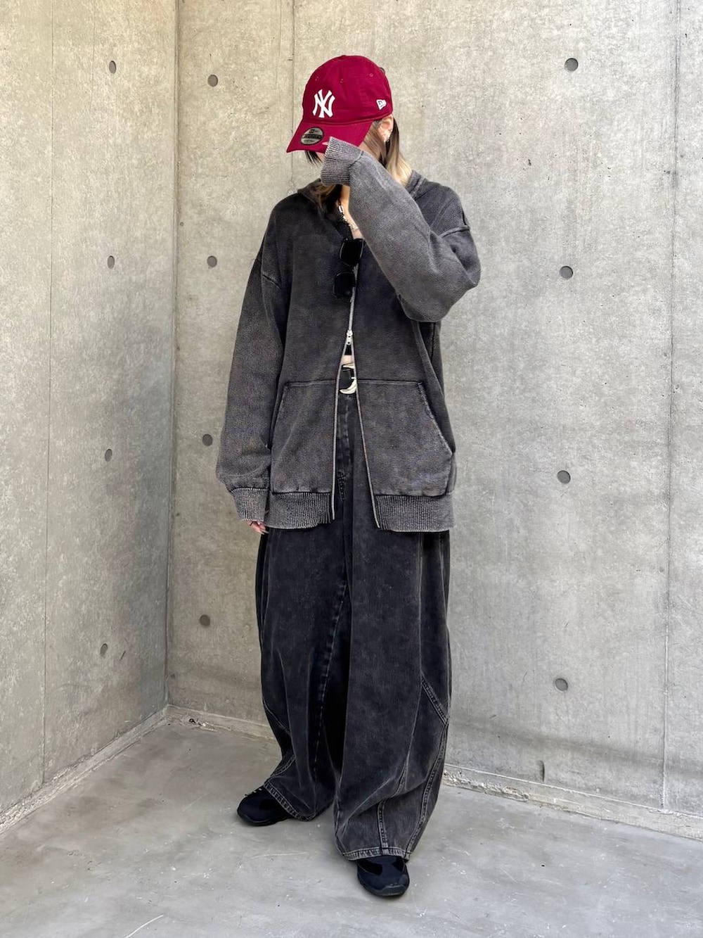 ブラック系のスニーカー、グレー系のパーカー、ブラック系のデニムパンツを着用したレディースの冬コーディネートの6枚目の写真