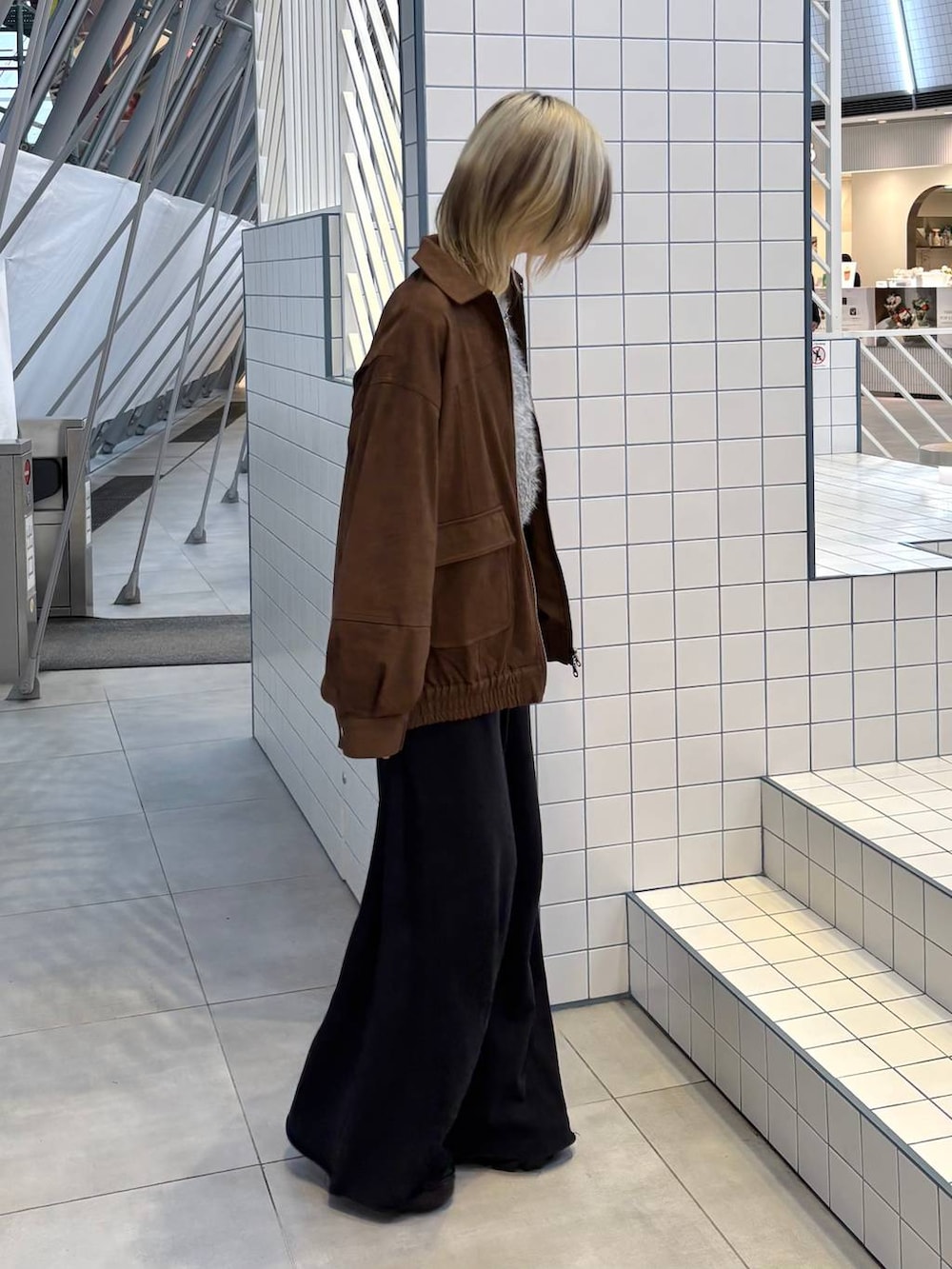 ブラック系のスニーカー、ブラック系のスウェットパンツ、ブラウン系のブルゾンを着用したレディースの冬コーディネートの7枚目の写真