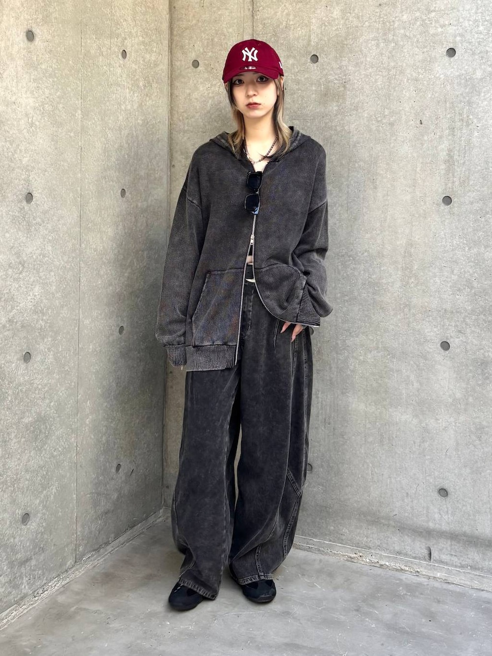 ブラック系のスニーカー、グレー系のパーカー、ブラック系のデニムパンツを着用したレディースの冬コーディネートの2枚目の写真