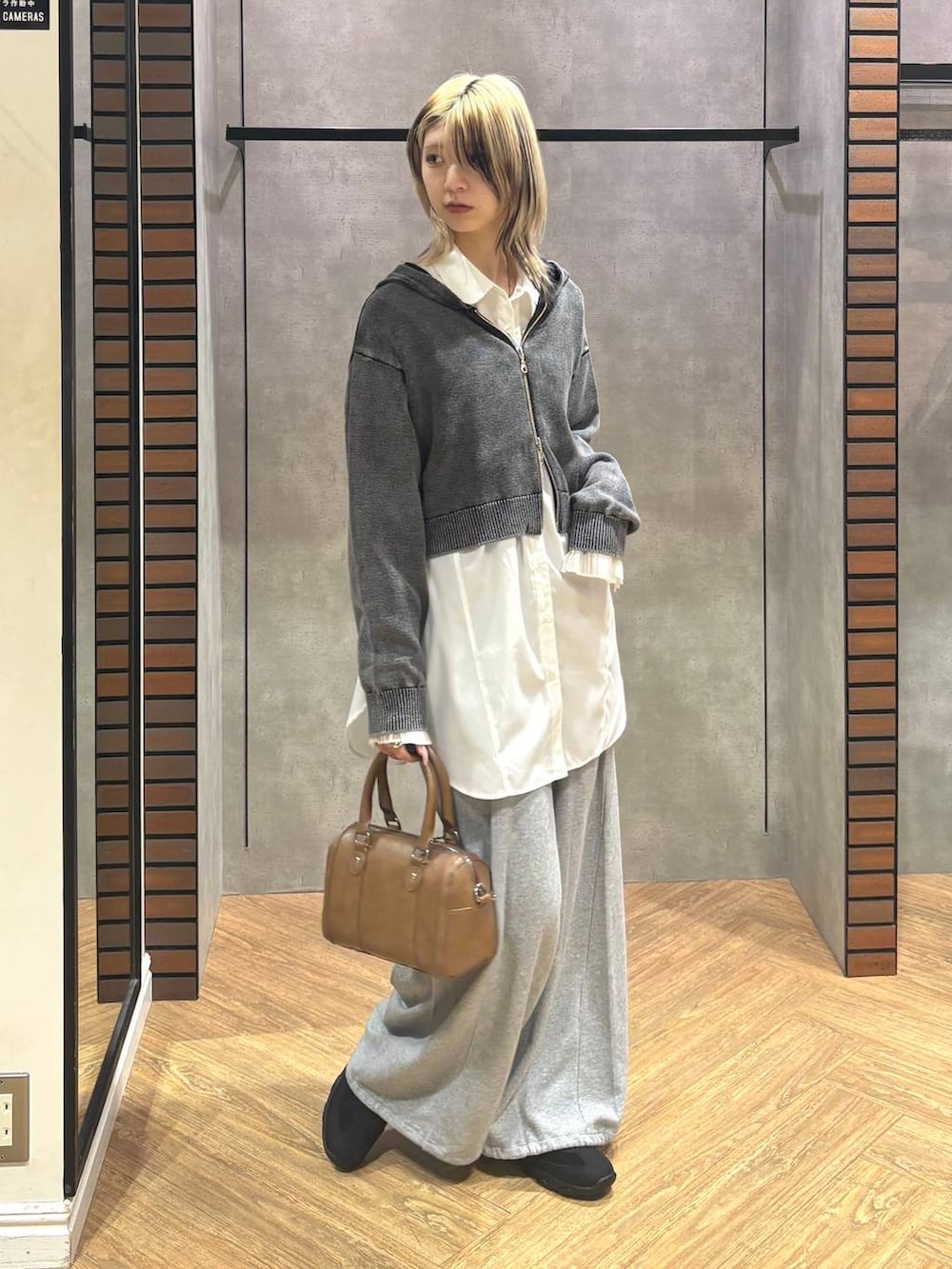 ブラウン系のボストンバッグ、ブラック系のスニーカー、グレー系のスウェットパンツを着用したレディースの冬コーディネートの8枚目の写真