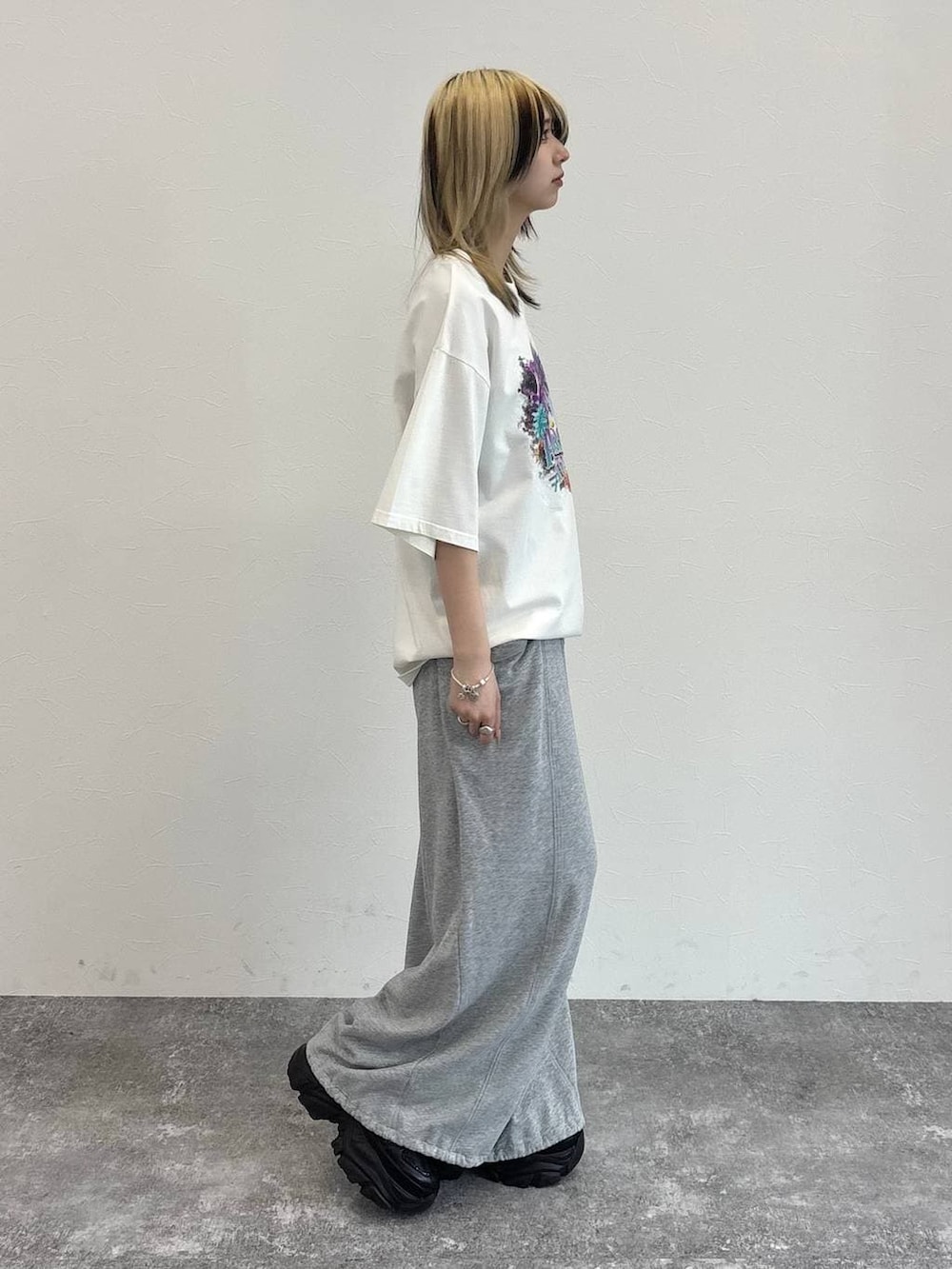 ブラック系のスニーカー、グレー系のスウェットパンツ、ホワイト系のTシャツ/カットソーを着用したレディースの春コーディネートの7枚目の写真