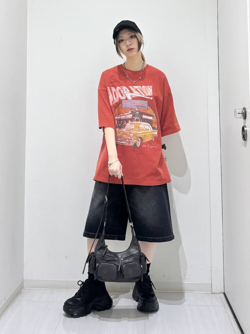 ブラック系のスニーカー、ブラック系のその他パンツ、レッド系のTシャツ/カットソーを着用したレディースの夏コーディネートの2枚目の写真