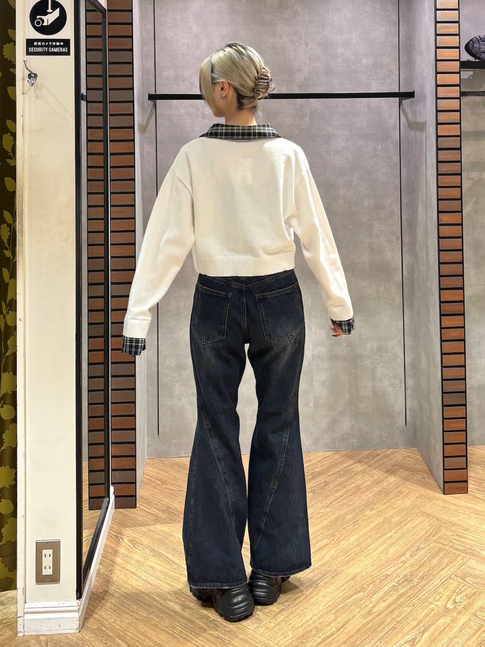 ブラック系のスニーカー、ブルー系のデニムパンツ、ホワイト系のニット/セーターを着用したレディースの秋コーディネートの5枚目の写真