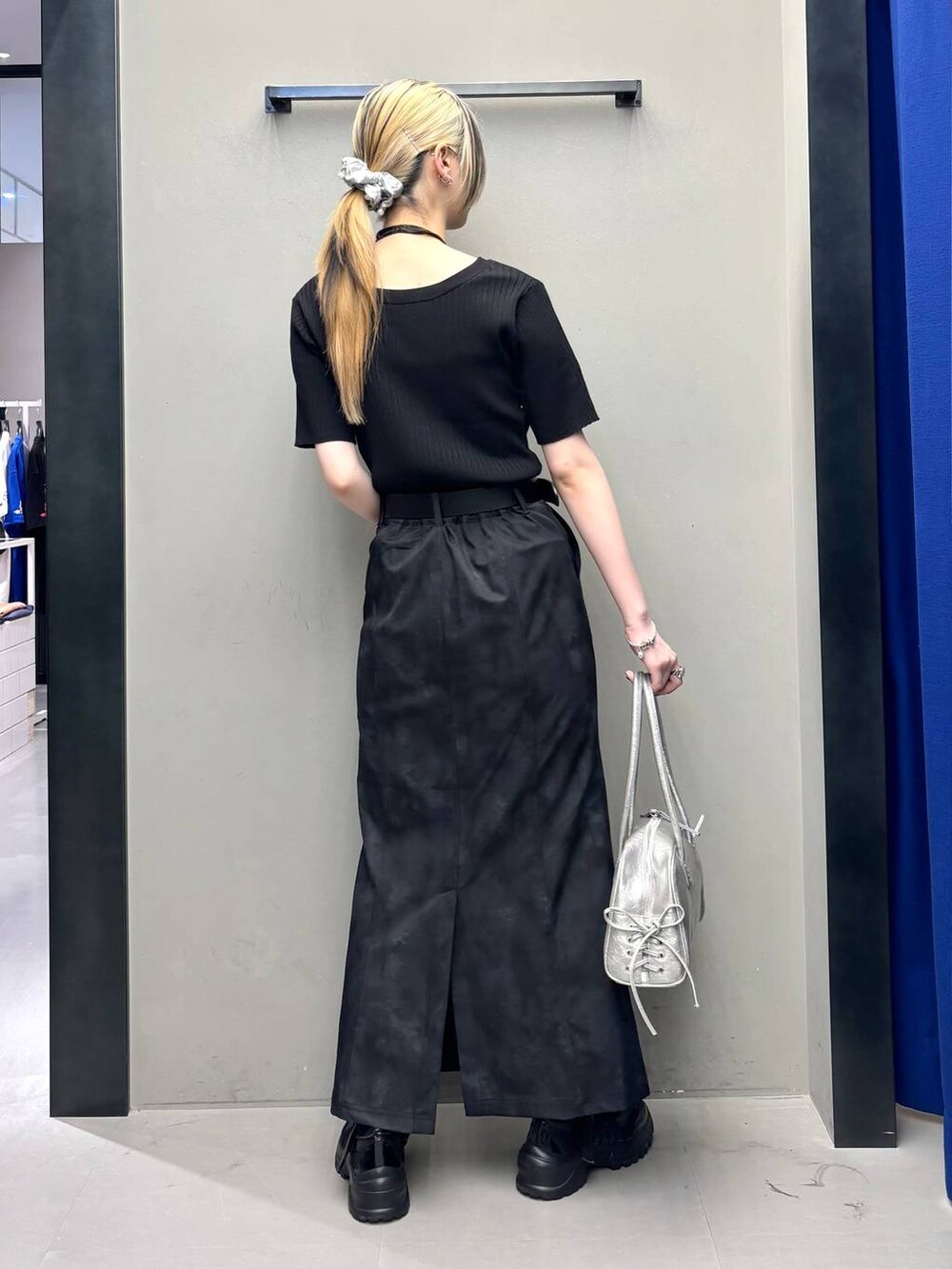 ブラック系のスニーカー、シルバー系のショルダーバッグ、ブラック系のニット/セーターを着用したレディースの春コーディネートの4枚目の写真