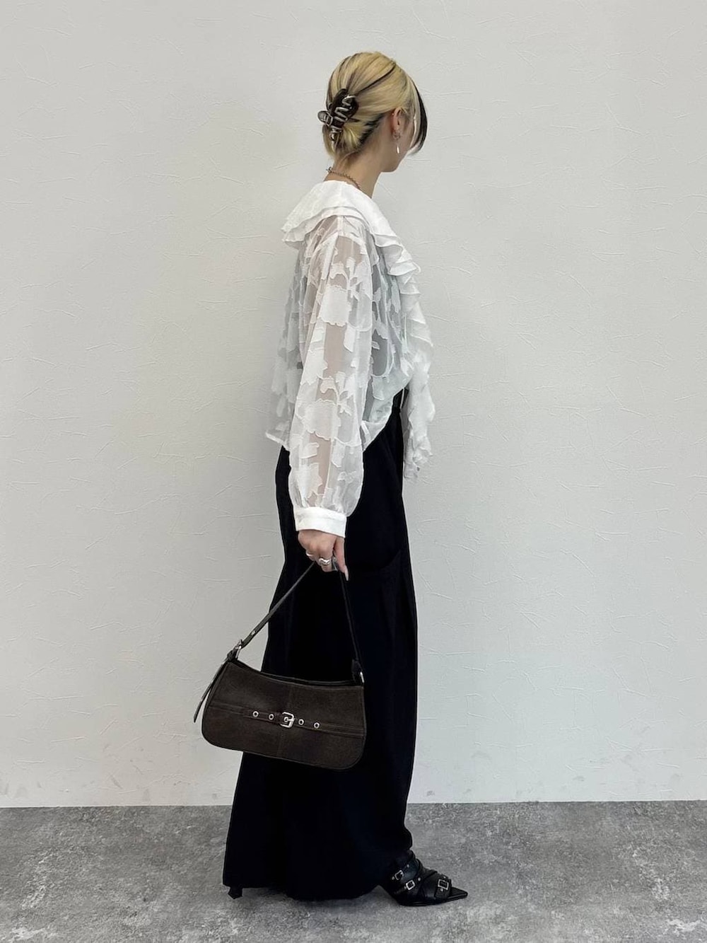 ブラウン系のハンドバッグ、ブラック系のサンダル、ホワイト系のシャツ/ブラウスを着用したレディースの春コーディネートの4枚目の写真