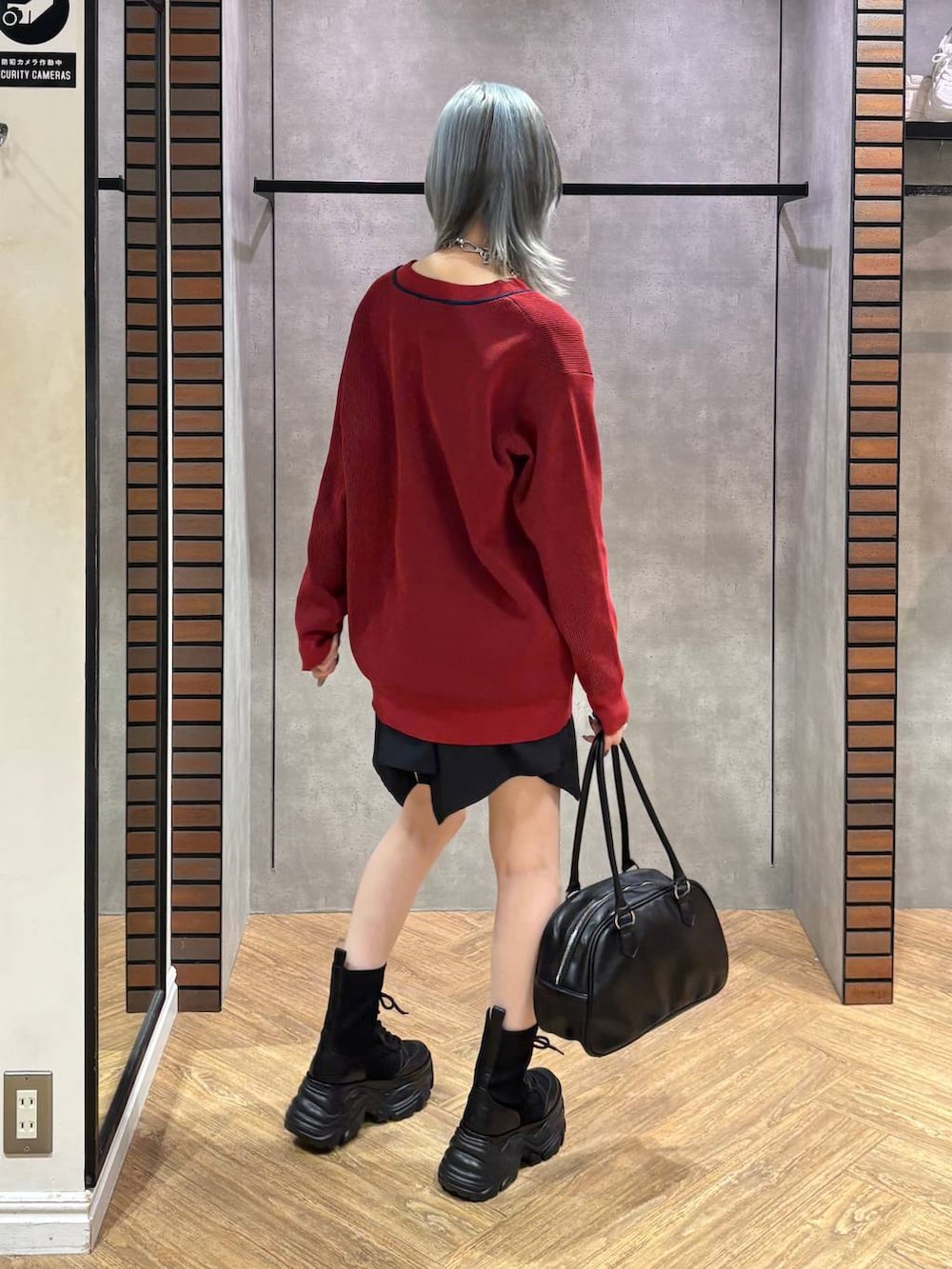 ブラック系のブーツ、ブラック系のキャミソール、ブラック系のスカートを着用したレディースの秋コーディネートの5枚目の写真