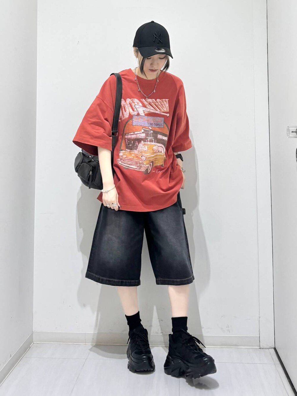 ブラック系のスニーカー、ブラック系のその他パンツ、レッド系のTシャツ/カットソーを着用したレディースの夏コーディネートの7枚目の写真