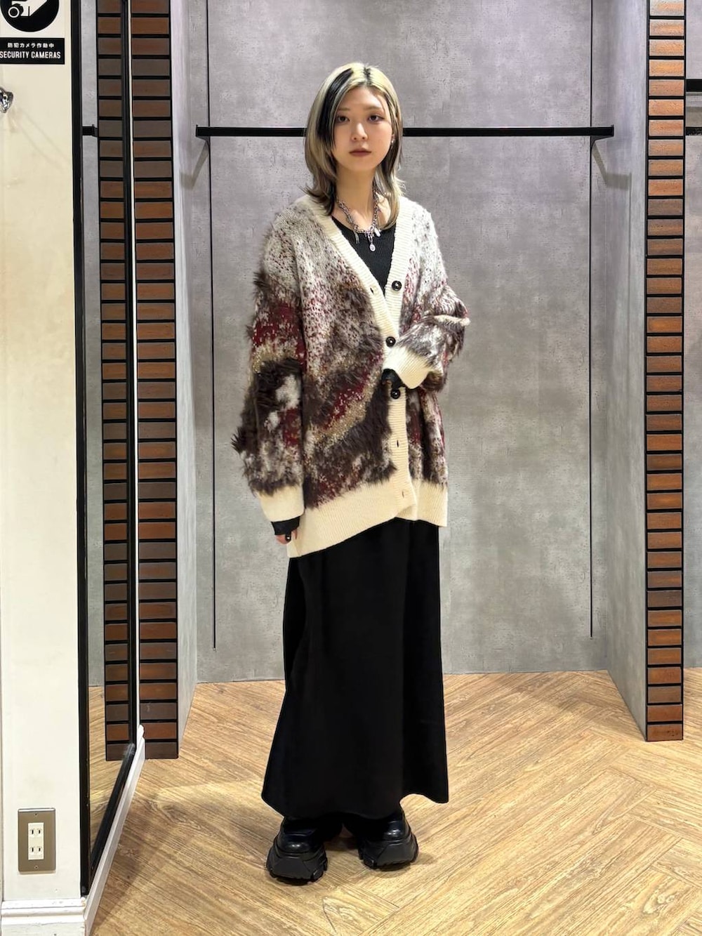 ブラック系のブーツ、ブラック系のニット/セーター、ホワイト系のカーディガン/ボレロを着用したレディースの冬コーディネートの3枚目の写真