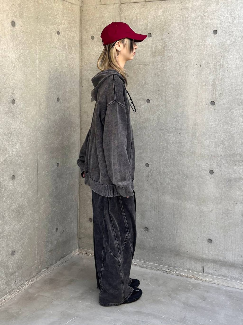 ブラック系のスニーカー、グレー系のパーカー、ブラック系のデニムパンツを着用したレディースの冬コーディネートの5枚目の写真