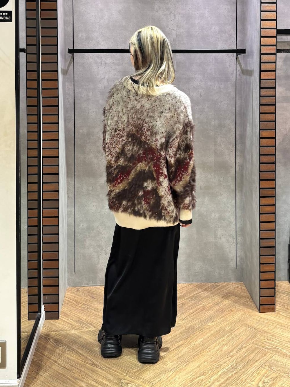 ブラック系のブーツ、ブラック系のニット/セーター、ホワイト系のカーディガン/ボレロを着用したレディースの冬コーディネートの5枚目の写真